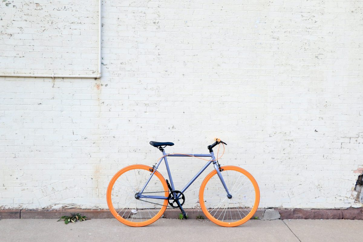 vélo coloré posé le long d'un mur blanc