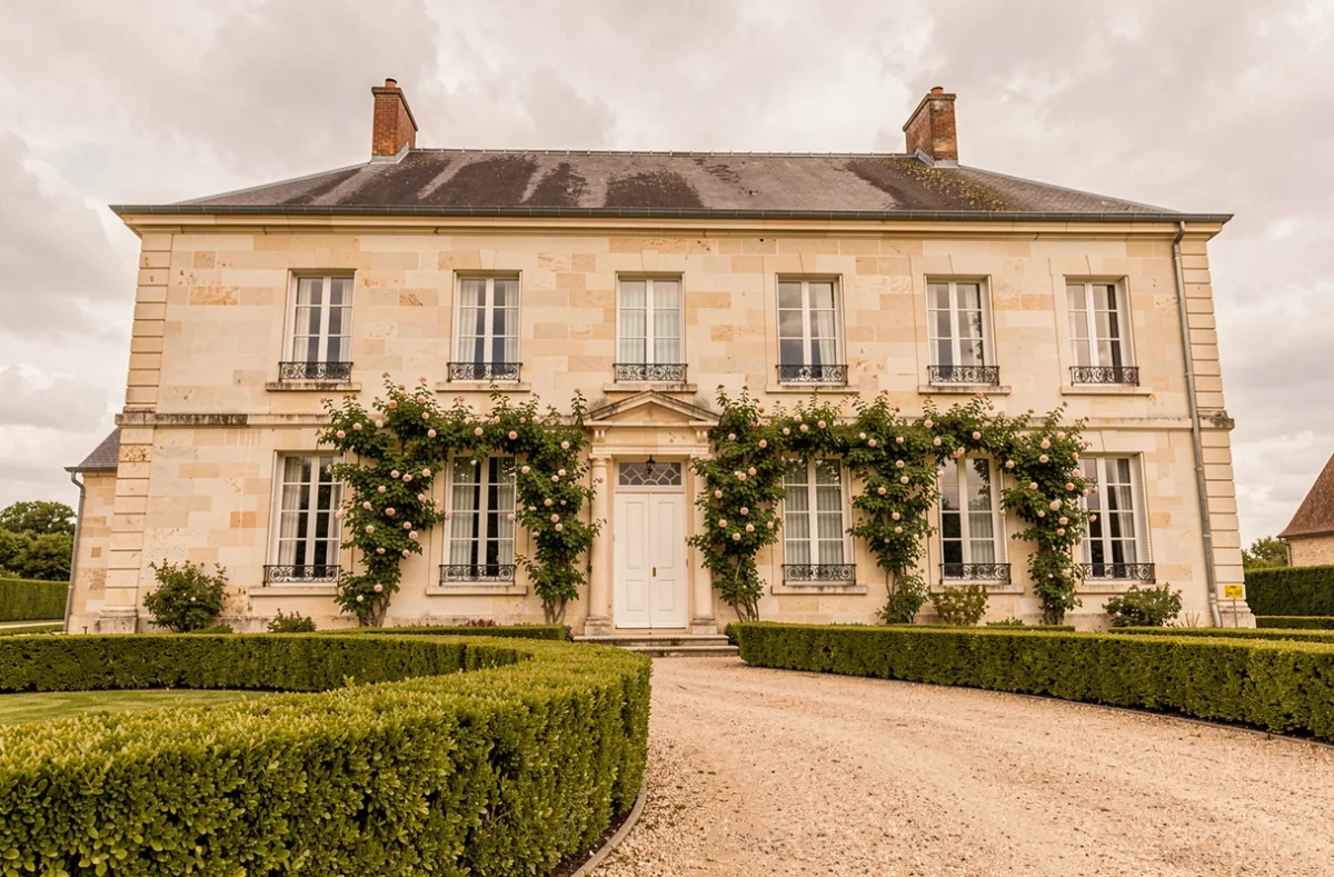 Maison bourgeoise du XVIIIe siècle de Maison Mouche à Beaumont-en-Auge avec rosiers grimpants