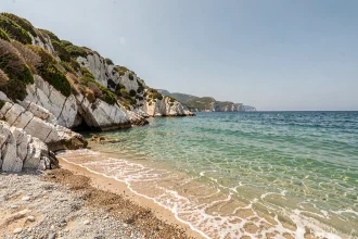 Vue panoramique de la Plage des 3 Pointes à Bonifacio avec ses eaux turquoise et ses falaises calcaires blanches en Corse